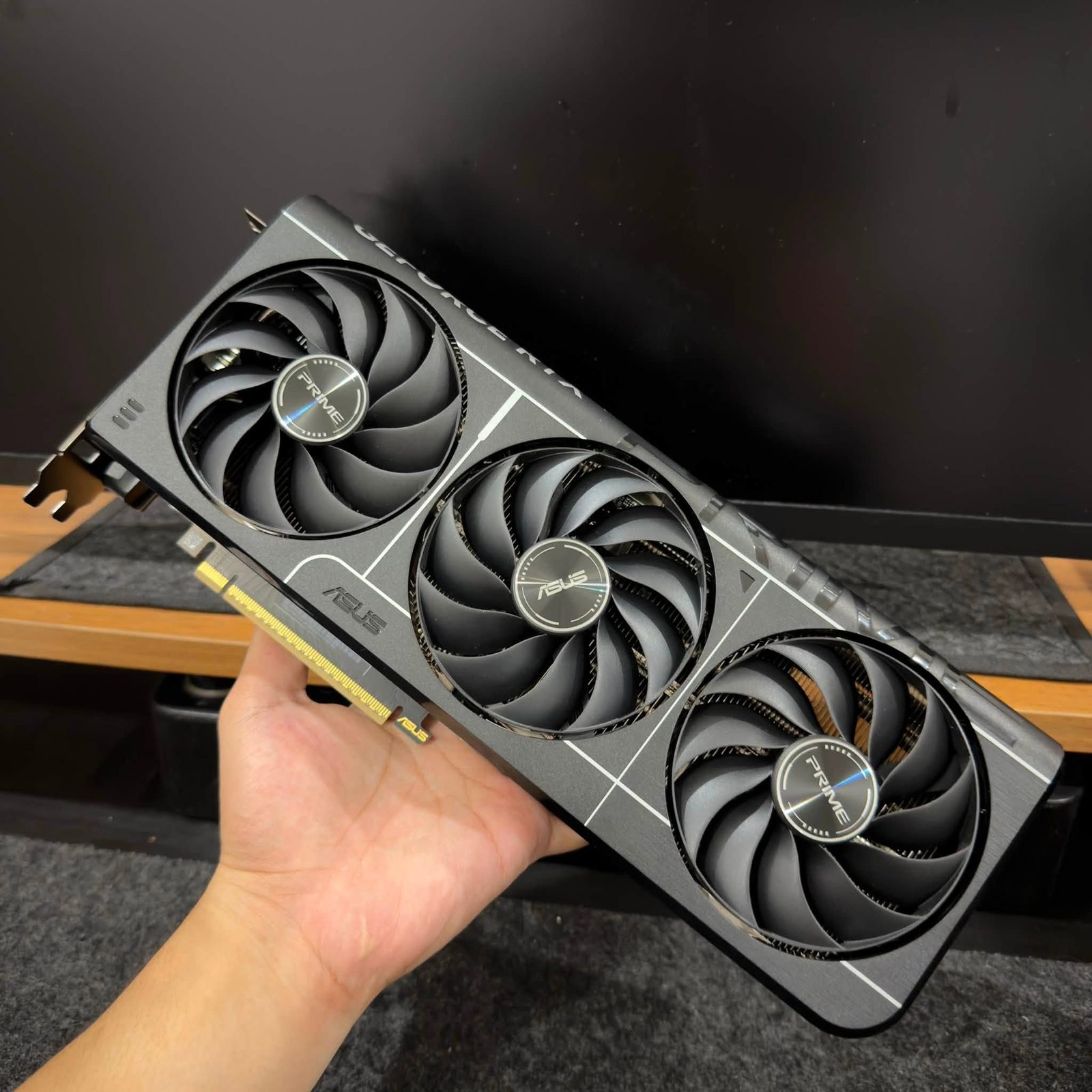 ASUS triple-fan graphics card in hand, before packing